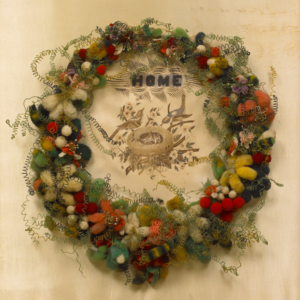 American, Wreath, ca. 1870, thread-covered wire and wool, mounted on ink drawing on wove paper and silk satin weave ground. Gift of Pamela Miller Ness and Paul Marc Ness in Memory of Professor and Mrs. Edwin Haviland Miller, 2003. (2003.39.19)